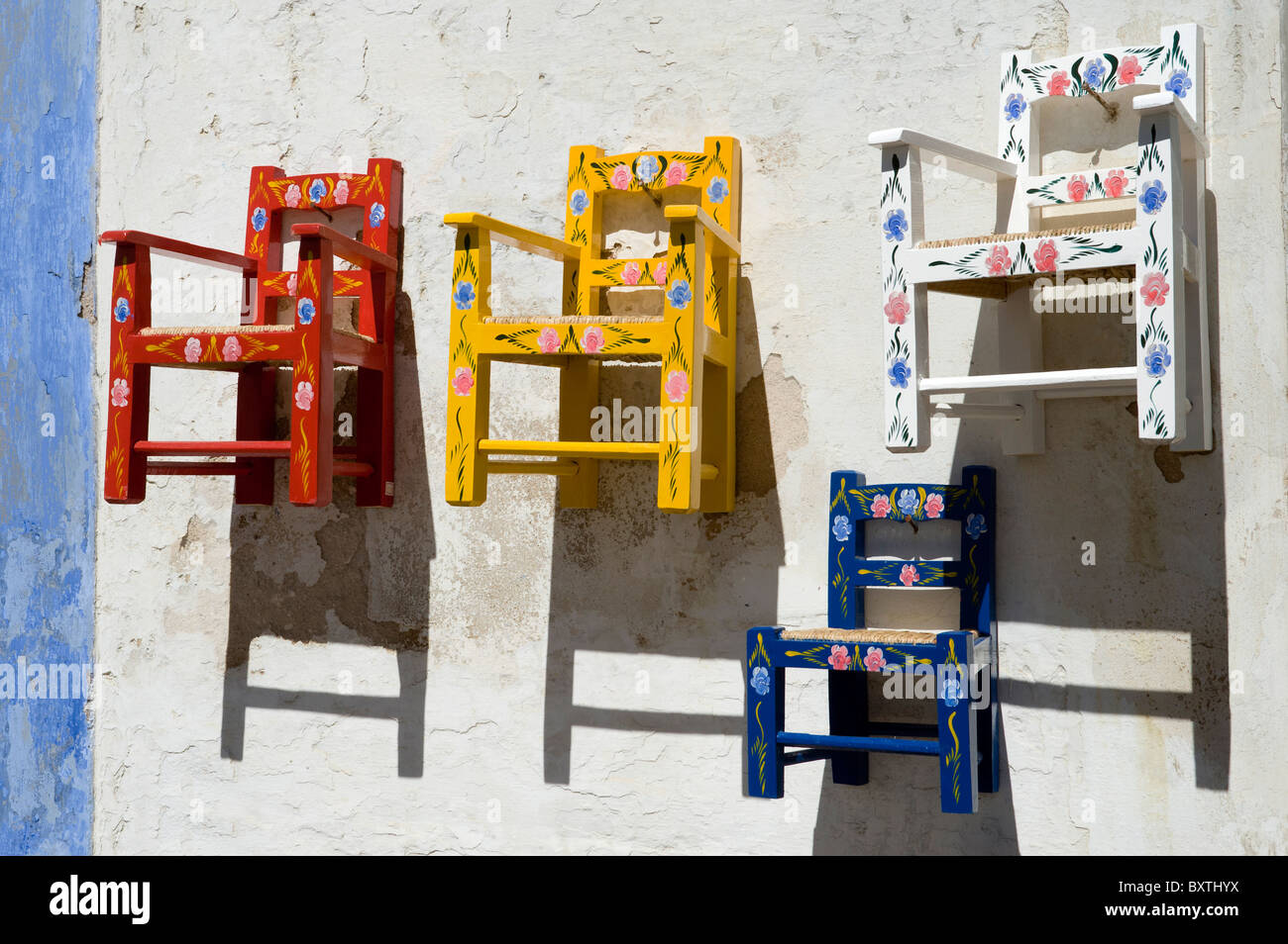 Il Portogallo, l'Alentejo, sedie per bambini dipinti in stile Alentejo al di fuori di un locale negozio di artigianato a Redondo Foto Stock