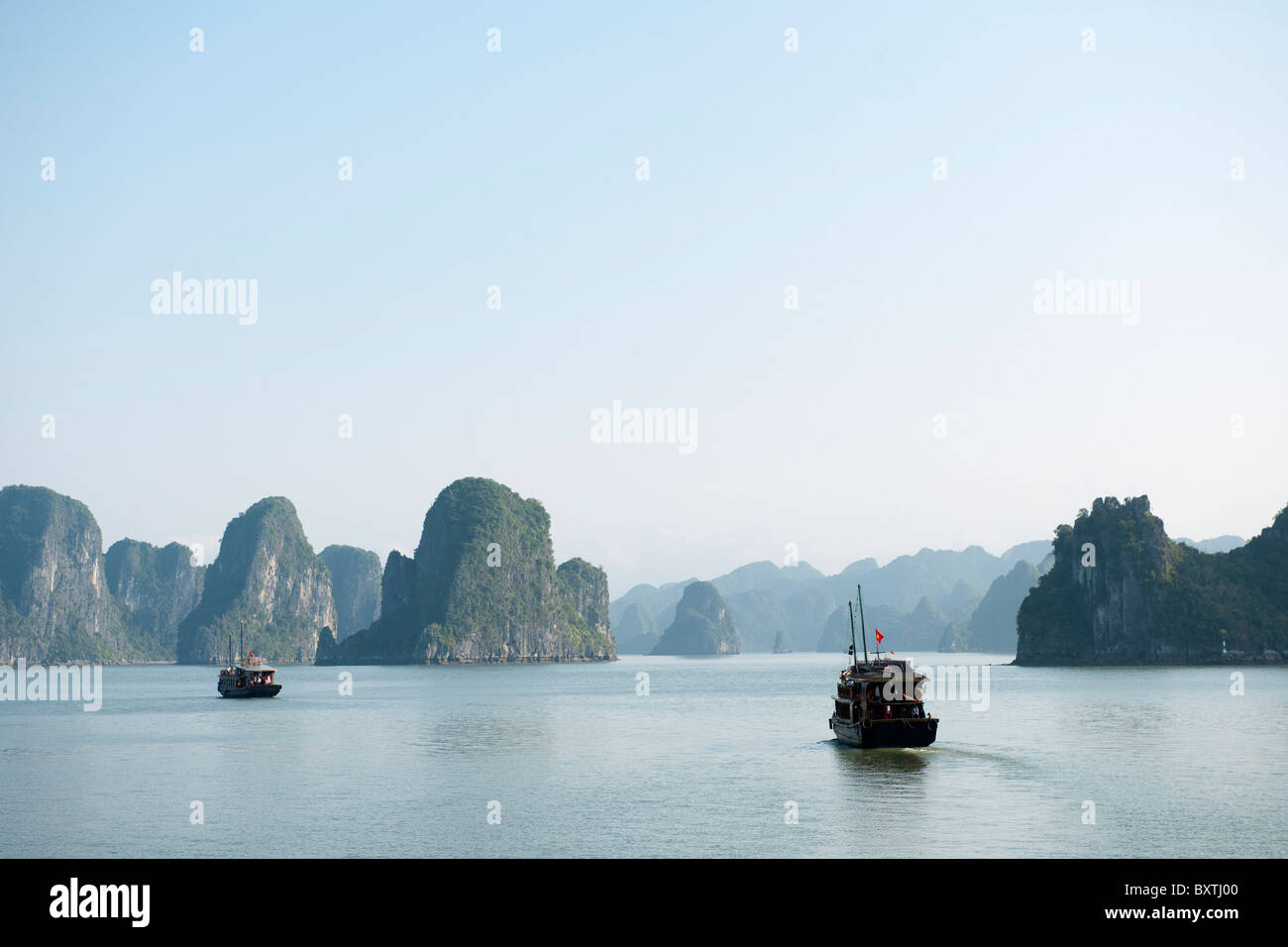 Barche nella baia di Halong, Vietnam Foto Stock