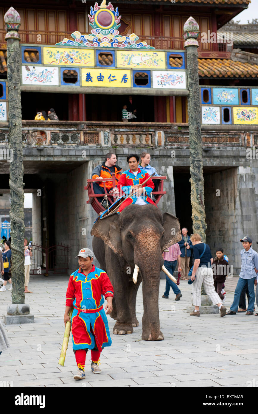 Equitazione turistica un elefante nella parte anteriore delle Ong Mon Gate, Città Imperiale, la Cittadella, la tinta, Vietnam Foto Stock