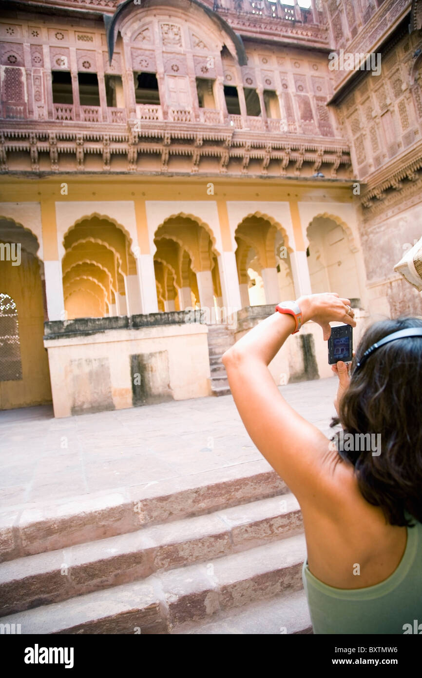 Donna ascoltando le cuffie fotografare in Forte Mehrangarh Foto Stock