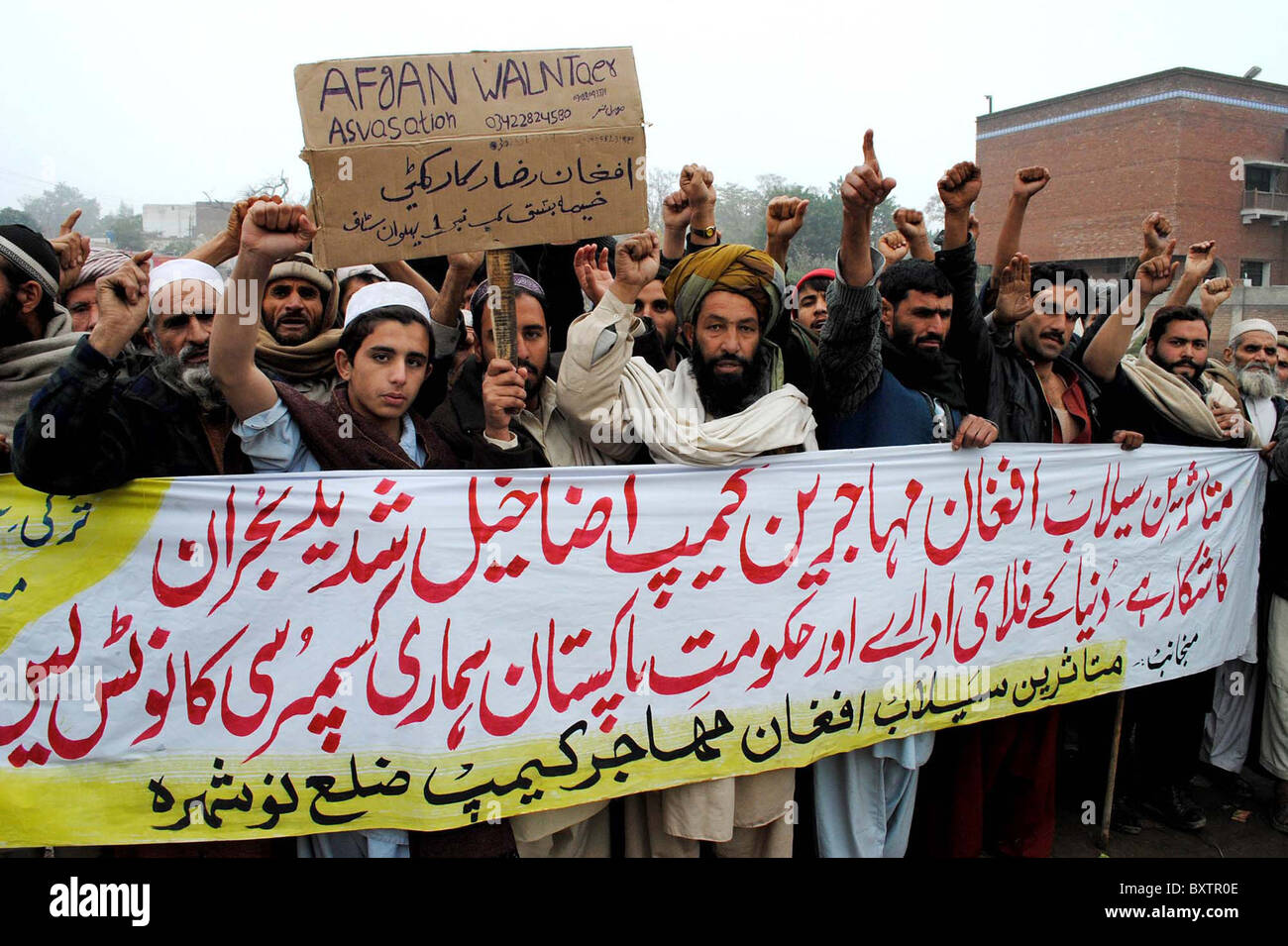 Flood affectees dei profughi afghani Camp distretto di Nowshera chant slogan in favore delle loro richieste durante il rally di protesta Foto Stock