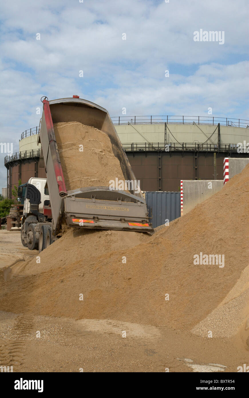 Lo scarico del camion di sabbia a opere in cemento Ipswich Suffolk REGNO UNITO Foto Stock