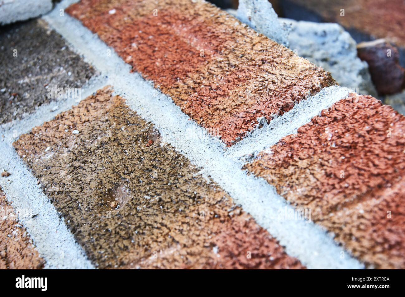 Close-up caduti sul muro di mattoni durante la demolizione di una casa. Grande sfondo con la diagonale e texture dettagliate. Foto Stock