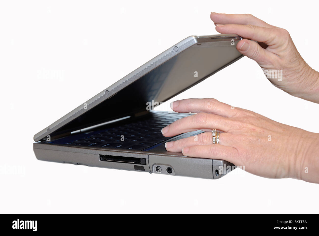 Un business donna chiudendo il suo laptop al termine di una intensa giornata di lavoro. Foto Stock