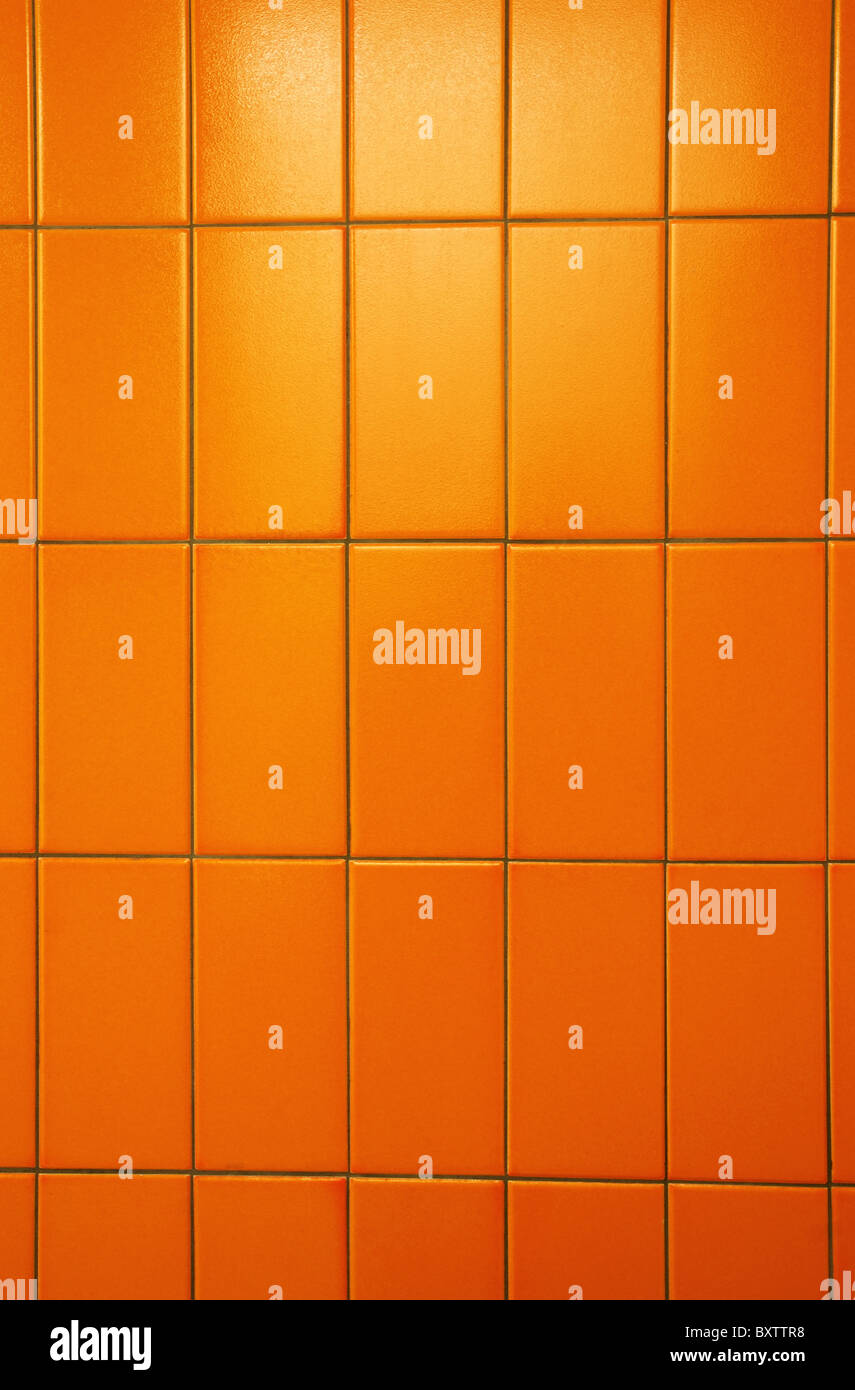 Orange piastrelle di un bagno pubblico parete. Colori eccezionali e piastrelle hanno anche la scorza d'arancia texture. Foto Stock
