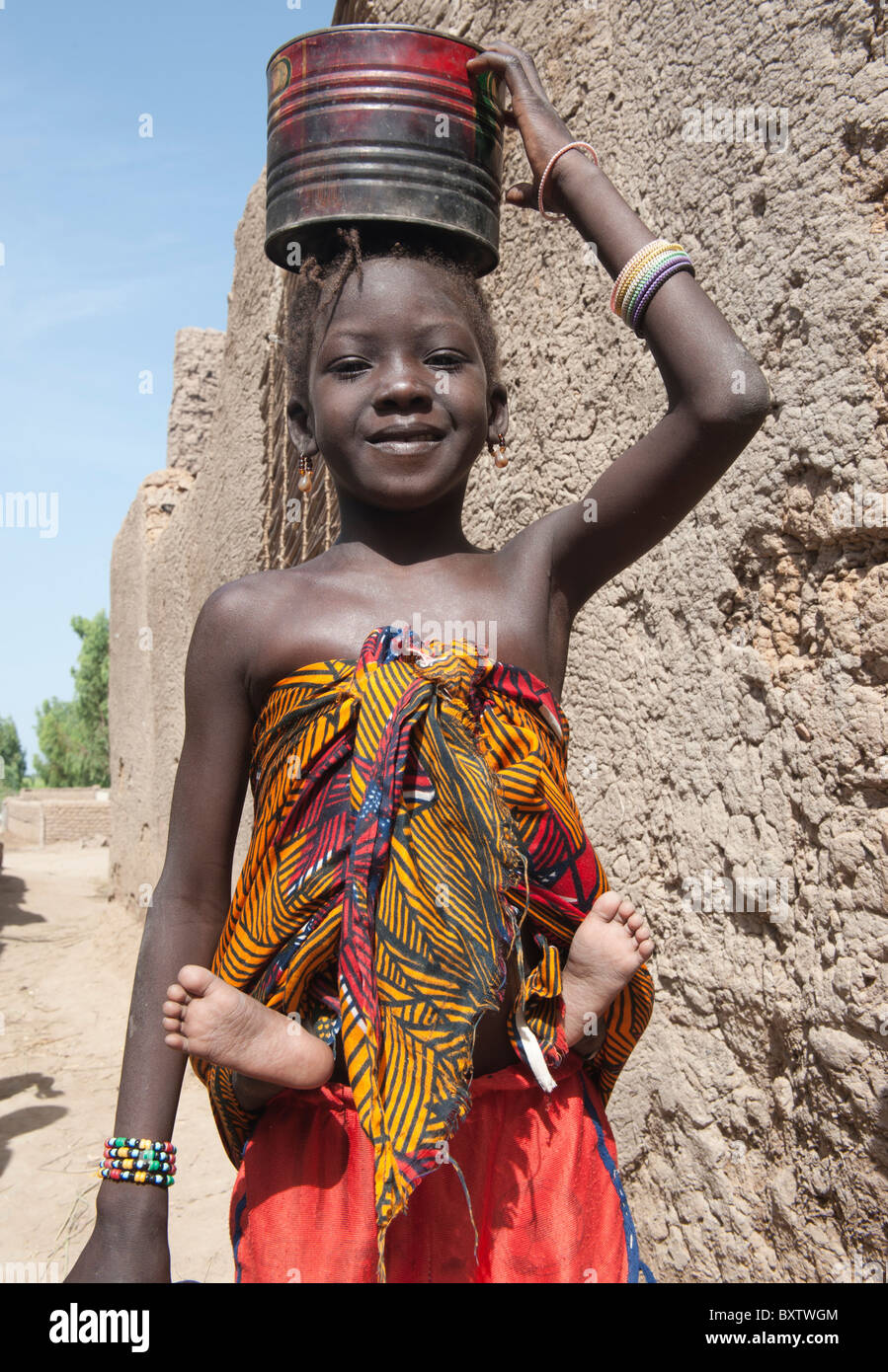 Giovane ragazza che porta un bambino sulla schiena. Sirimou, Mali. Foto Stock