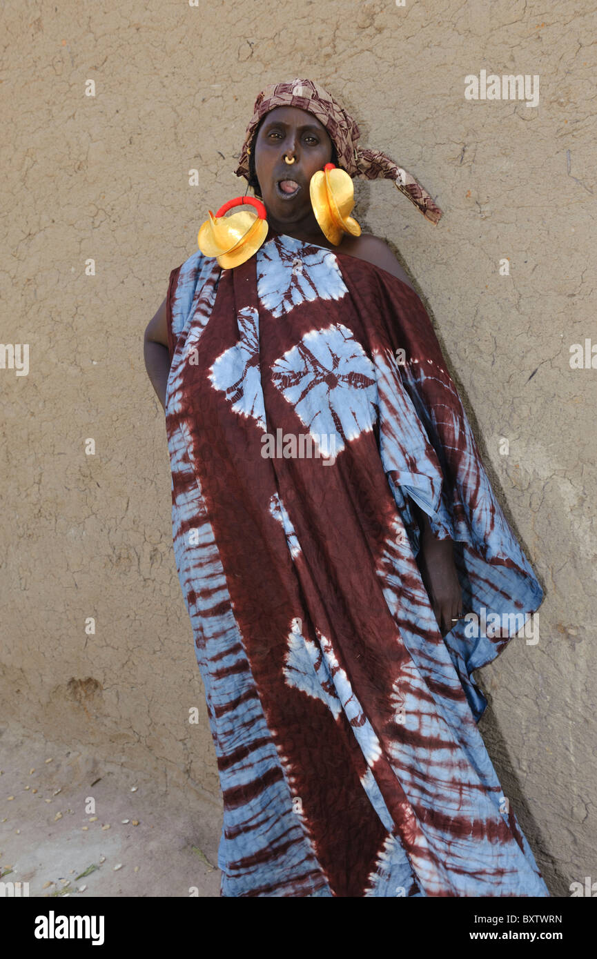 Peul donna gigante demontrating orecchini d'oro in Peul insediamento di Senossa, Mali Foto Stock