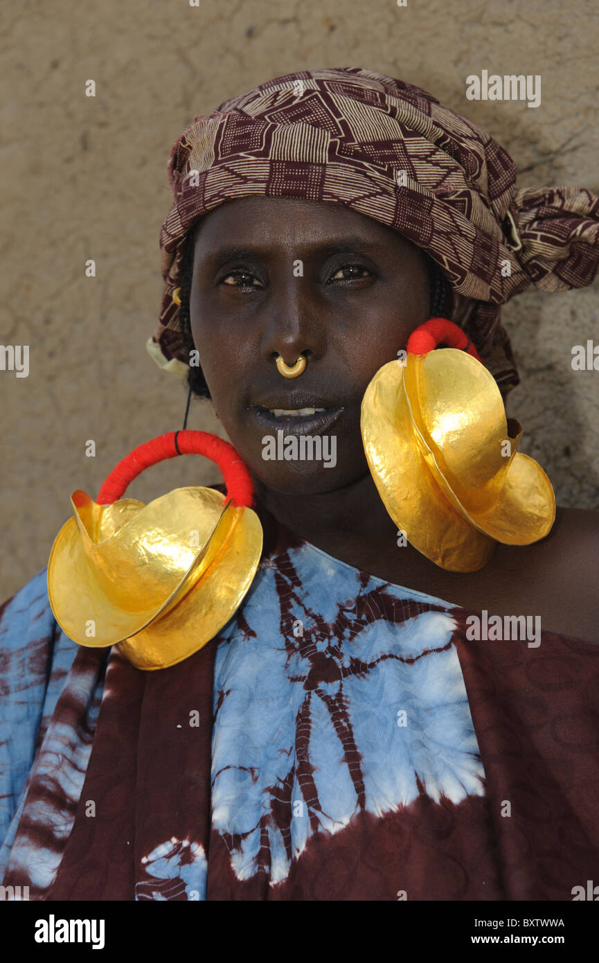 Peul donna gigante demontrating orecchini d'oro in Peul insediamento di Senossa, Mali Foto Stock