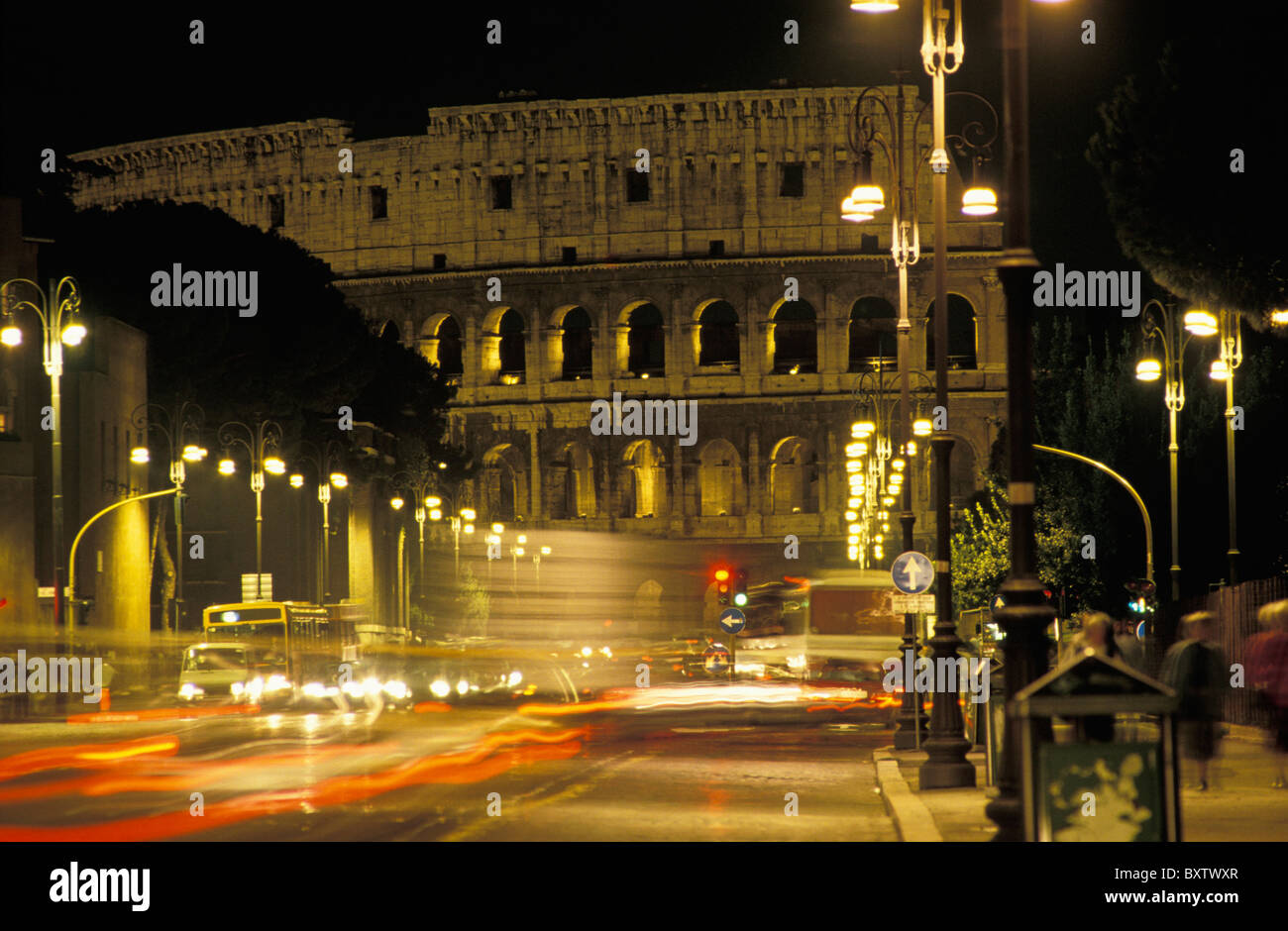 Sentieri di luce e il Colosseo di notte Foto Stock