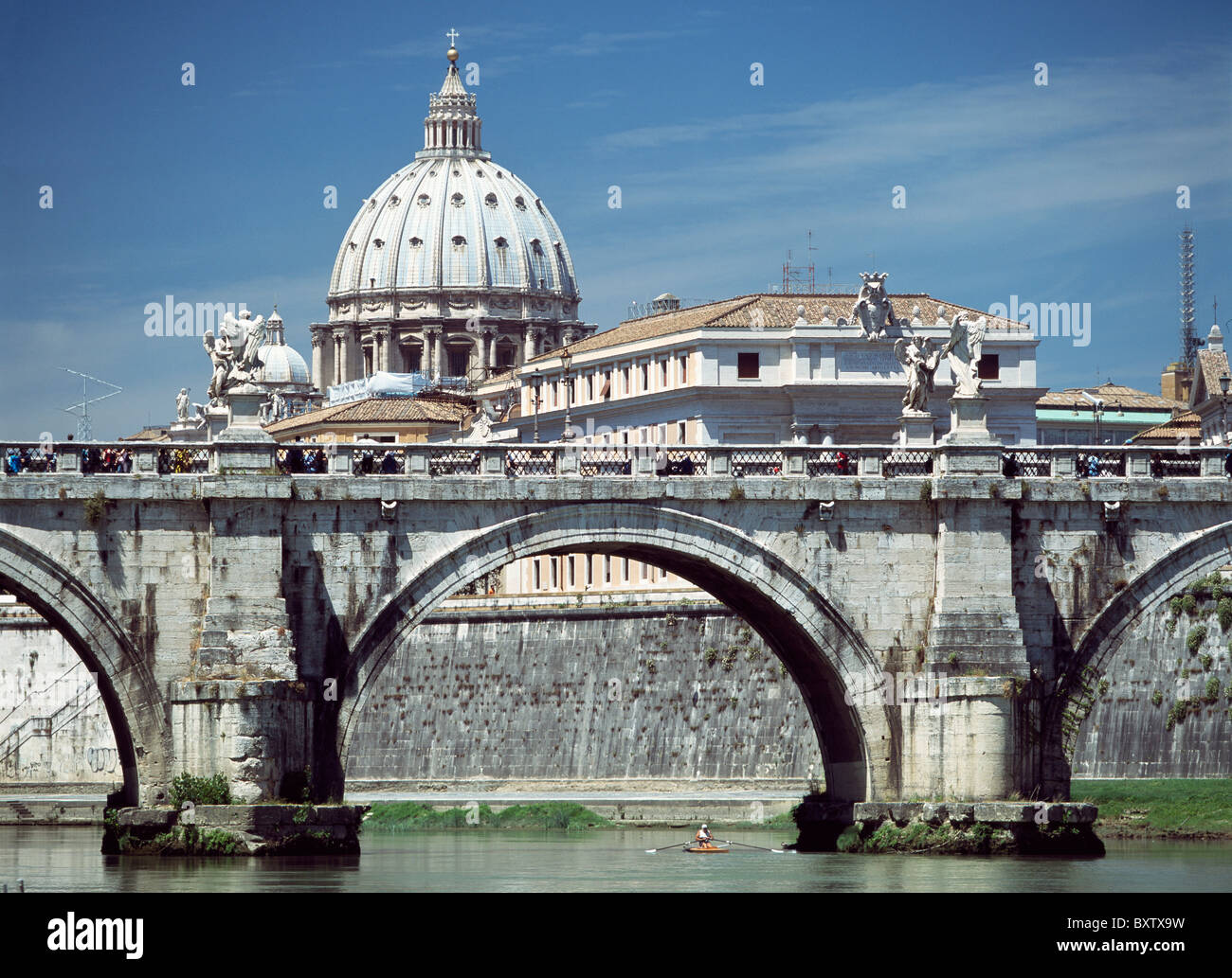 Uomo Scull a remi sotto il ponte sul fiume Tevere con la cupola della Basilica di San Pietro in background Foto Stock