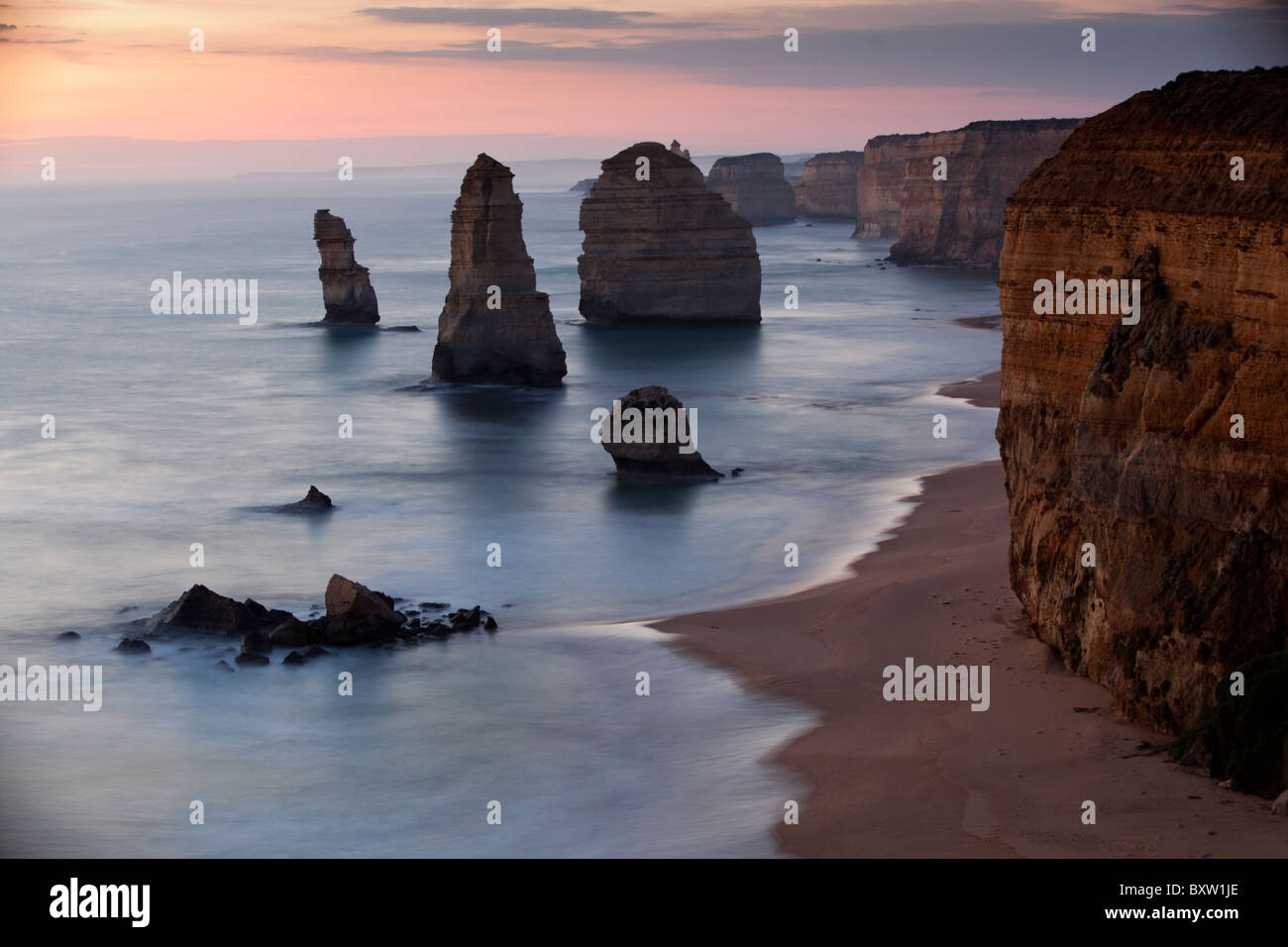 Australia Victoria Parco nazionale di Port Campbell onde dal Mare di Tasman crash sulla spiaggia al di sotto di dodici Apostoli al tramonto in estate Foto Stock