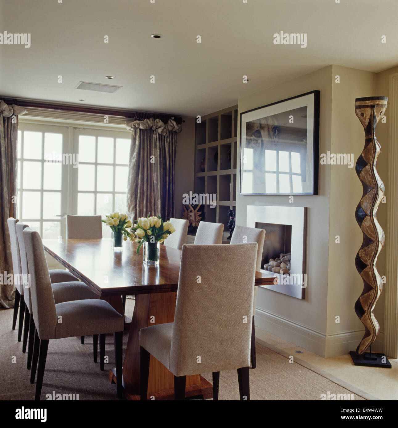 La crema sedie imbottite e tavolo in legno nel tradizionale sala da pranzo  con alte colonne di legno accanto al caminetto Foto stock - Alamy