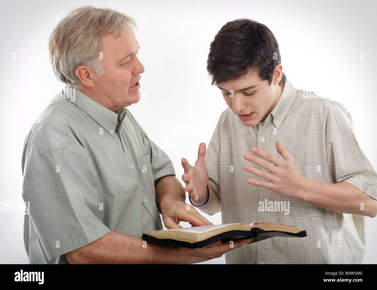 Padre (o predicatore) spiega la Parola di Dio per il suo figlio (o a un giovane uomo) Foto Stock