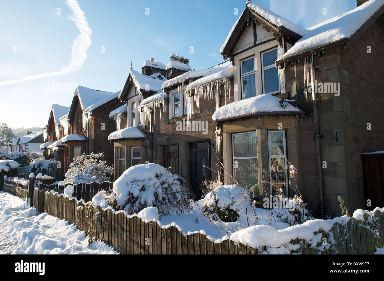 Ghiaccioli pendono dal tetto di una casa in inverno Foto Stock