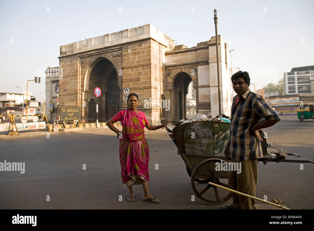 Un uomo e una donna spazzare la strada da Delhi Darwaja in Ahmedabad, Gujarat, India. Foto Stock