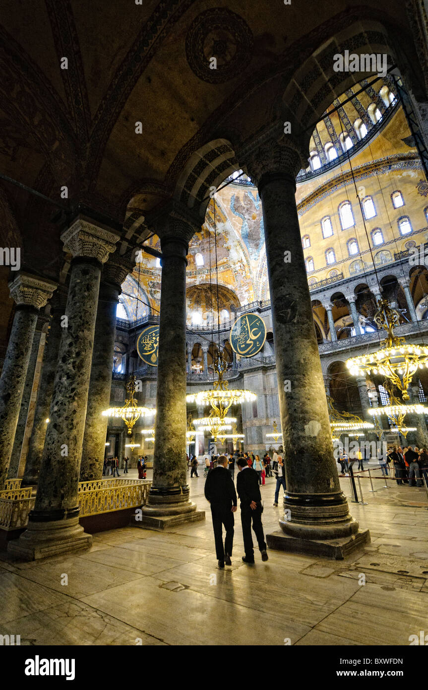 Hagia Sophia Interior Istanbul Turchia // ISTANBUL, Turchia - la vasta sala principale di Hagia Sophia mostra il suo notevole design architettonico bizantino, con la sua imponente cupola centrale supportata da pendenti e semi-cupole. L'interno presenta elementi cristiani e islamici, tra cui mosaici bizantini, calligrafia ottomana e grandi avize ottomane (lampadari). Enormi colonne e pannelli in marmo rivestono lo spazio, dimostrando la grandezza dell'ingegneria architettonica del vi secolo. Foto Stock
