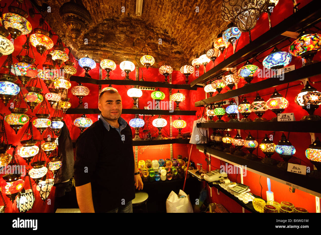 Lampade in vetro a mosaico Grand Bazaar Istanbul // ISTANBUL, Turchia - vivaci lampade in vetro a mosaico illuminano un negozio nello storico Grand Bazaar di Istanbul. La gamma colorata di lampade tradizionali turche crea un'abbagliante esposizione di artigianato artigianale. Queste lampade distintive, che combinano vetro colorato e metallo, rappresentano uno dei molti mestieri tradizionali disponibili in questo mercato secolare. Foto Stock