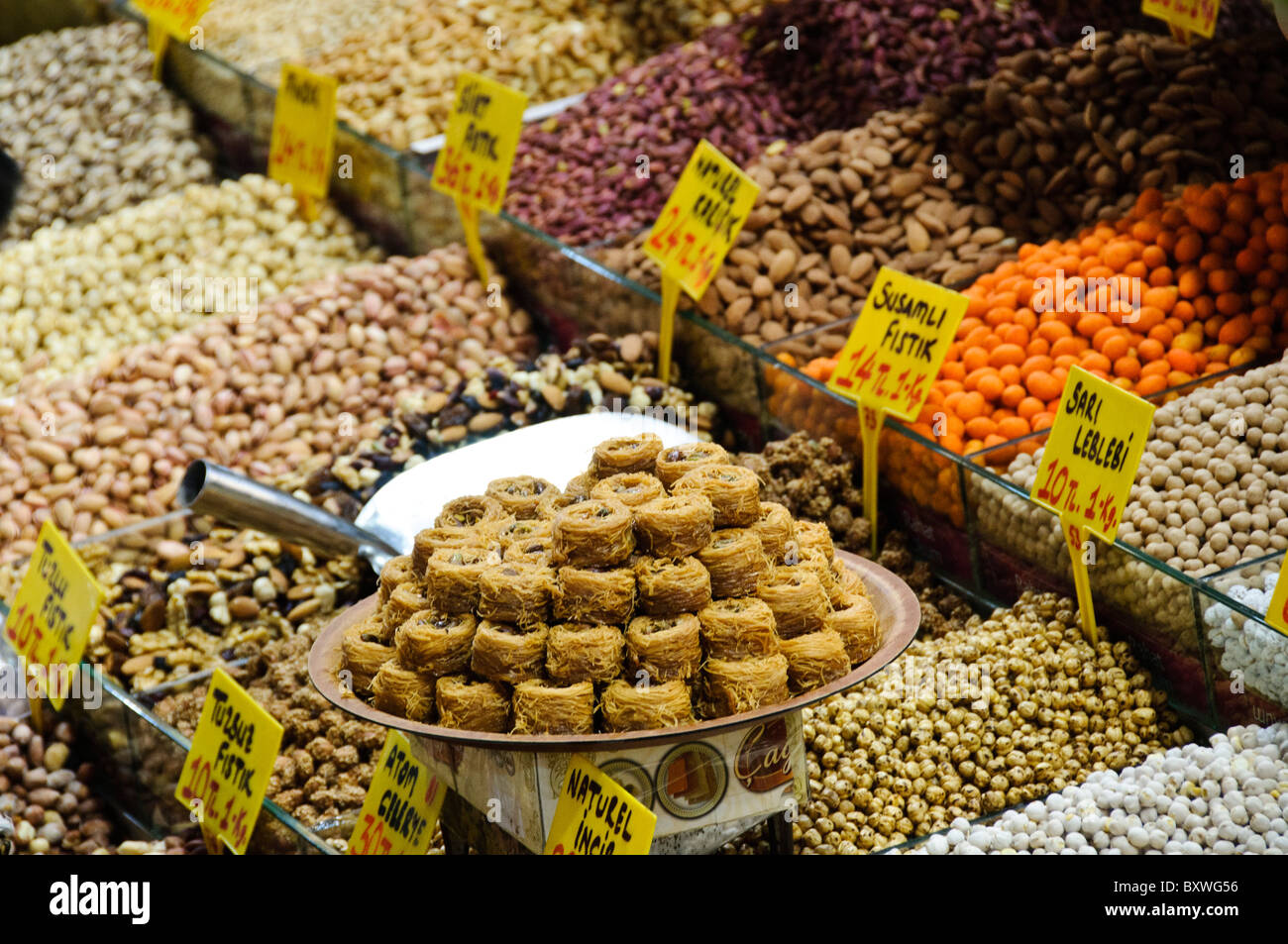 Egyptian Spice Bazaar spezie e legumi Istanbul // ISTANBUL, Turchia - spezie e legumi colorati sono esposti in vendita presso il Bazaar egiziano (noto anche come Bazaar delle spezie) a Istanbul. Il mercato presenta vari prodotti, tra cui sesamo, ceci e altre spezie, con cartellini dei prezzi ed etichette in turco. Il Bazar egiziano, costruito nel XVII secolo, è uno dei più antichi mercati coperti di Istanbul e una delle principali destinazioni turistiche. Situato nel quartiere di Eminönü vicino al Corno d'Oro, il bazar tradizionalmente specializzato in spezie, erbe e medicinali importati dall'Egitto e da altri paesi Foto Stock