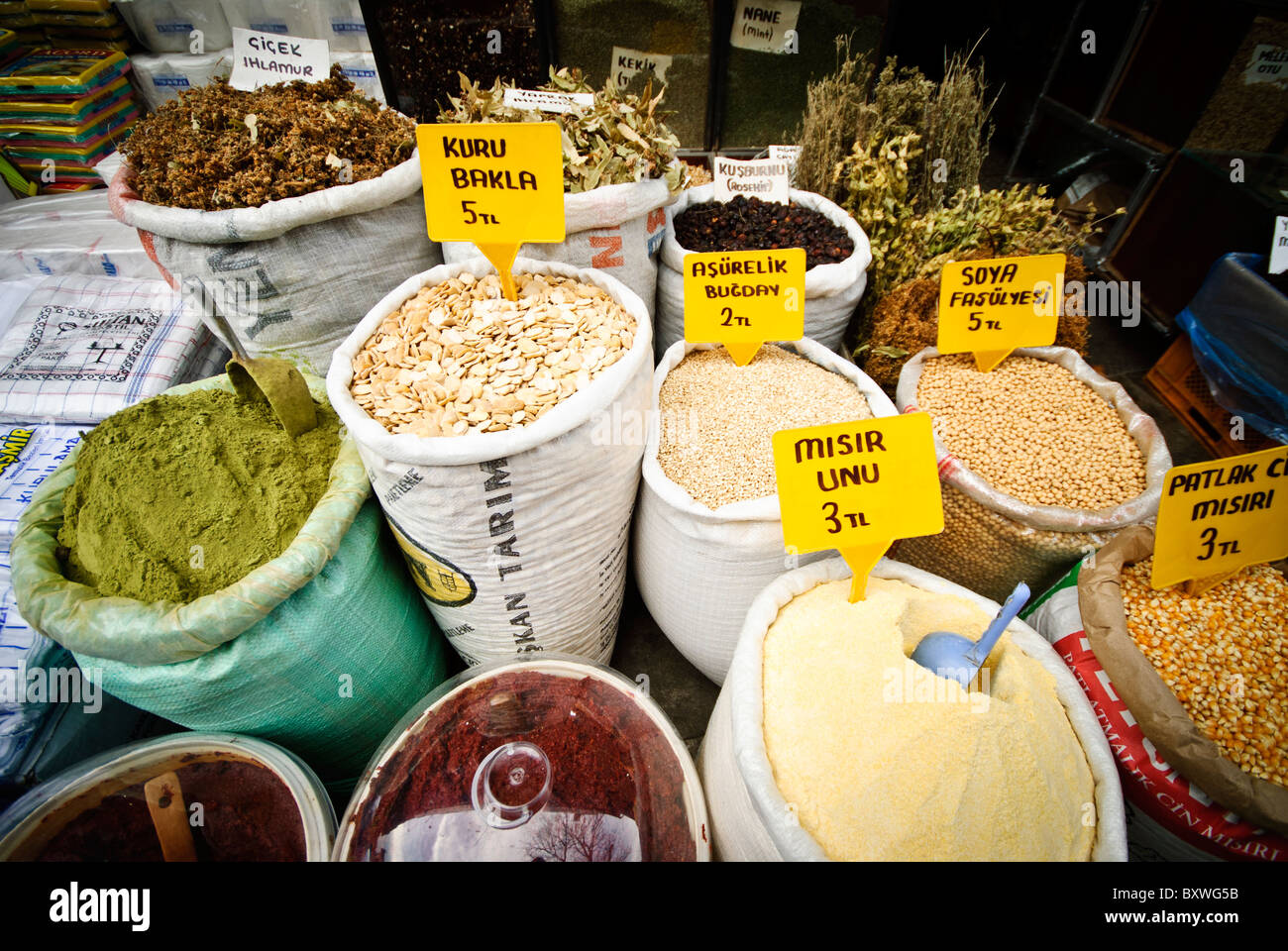 Spice Bazaar Herbs and Spices display Istanbul Turkey // ISTANBUL, Turkey — Un'esposizione di erbe, spezie e prodotti agricoli si trova vicino allo storico Bazaar delle spezie (Misir Carsisi). La selezione include ingredienti tradizionali turchi come erbe secche, tè e ingredienti da cucina con i prezzi indicati nella Lira turca (TL). Questo negozio rappresenta l'espansione del commercio delle spezie oltre le mura del bazar nelle strade circostanti del quartiere Eminonu. Foto Stock