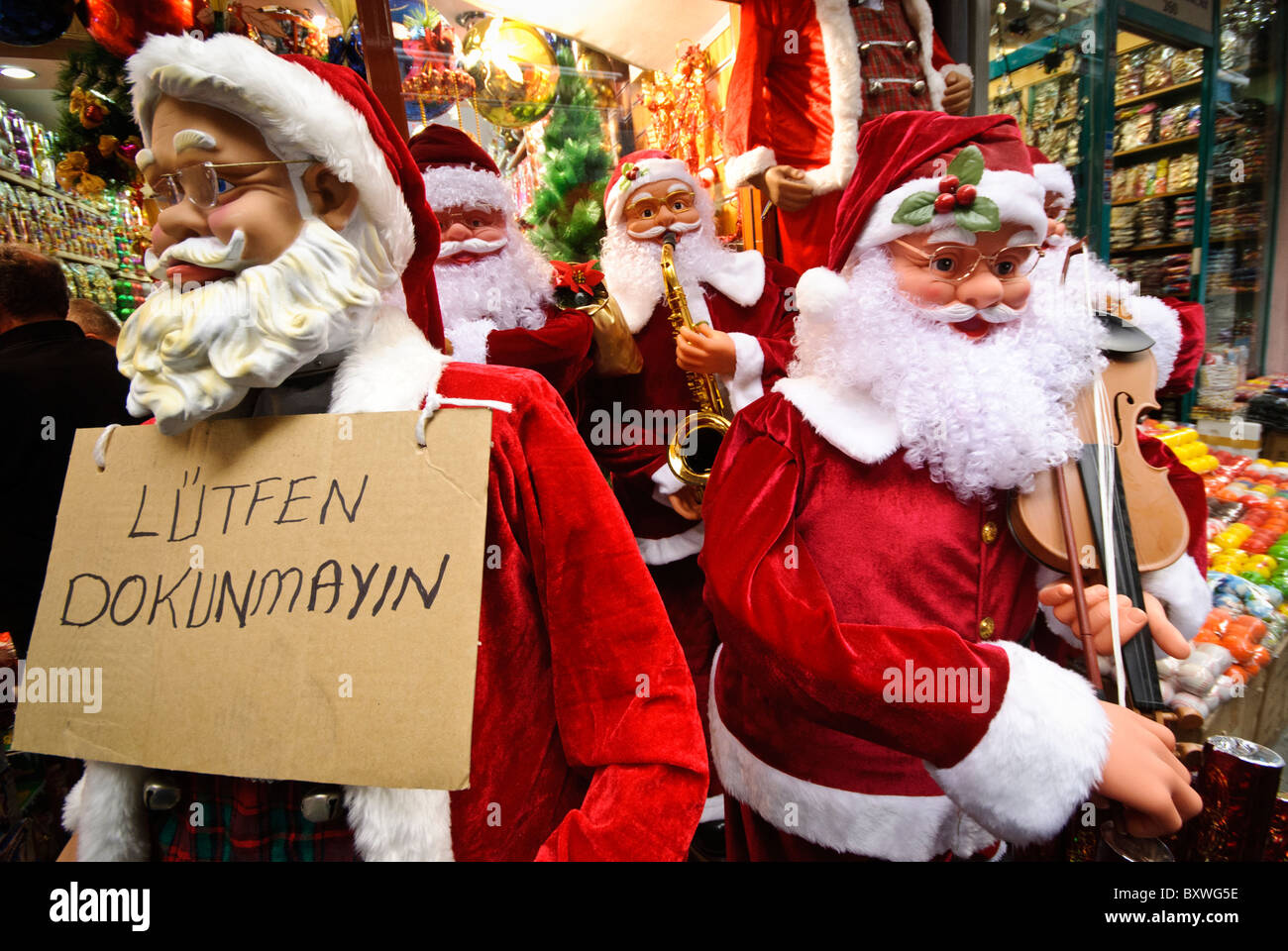 Grand Bazaar di Santa Mannequins Istanbul Turchia // ISTANBUL, Turchia - manichini di Santa grandezza fuori da un negozio appena fuori dallo storico Grand Bazaar di Istanbul. Il Grand Bazaar, uno dei mercati coperti più grandi e antichi del mondo, è un vivace centro commerciale e culturale di Istanbul. Caratterizzato da un labirinto di oltre 4.000 negozi, offre una vivace gamma di prodotti, da spezie e gioielli a tessuti e ceramiche. L'architettura storica e l'atmosfera vivace del Grand Bazaar attirano milioni di visitatori ogni anno. Il cartello recita: Per favore, non toccare. Foto Stock