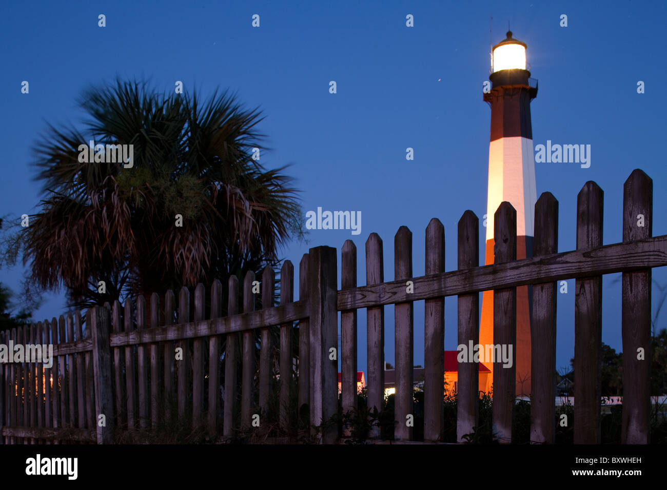 Stati Uniti d'America, Georgia, Tybee Island, weathered legno Picket Fence e Tybee faro al tramonto in serata estiva Foto Stock