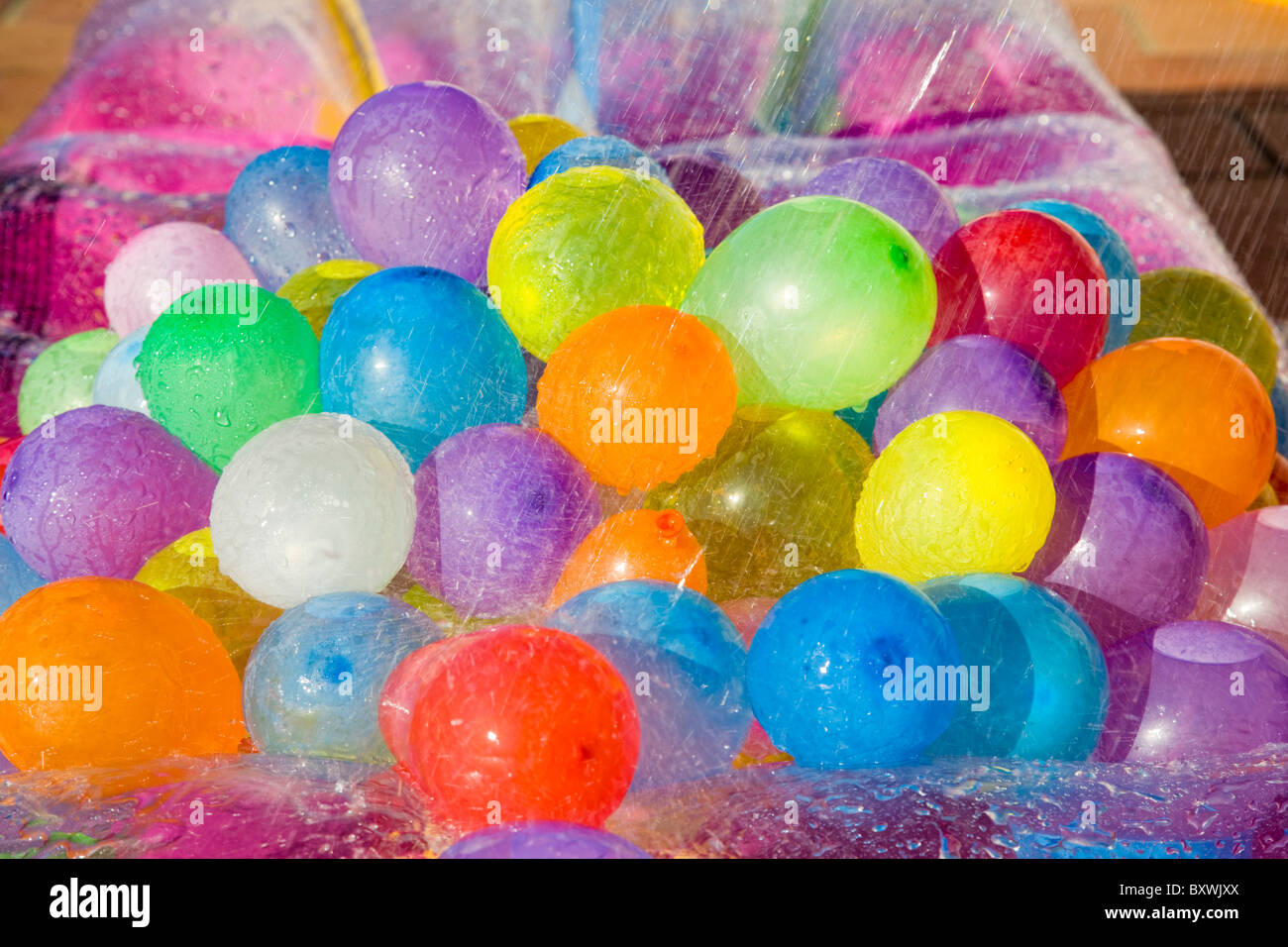 Gocce d'acqua che cadono su acqua multicolore palloncini pieni Foto Stock