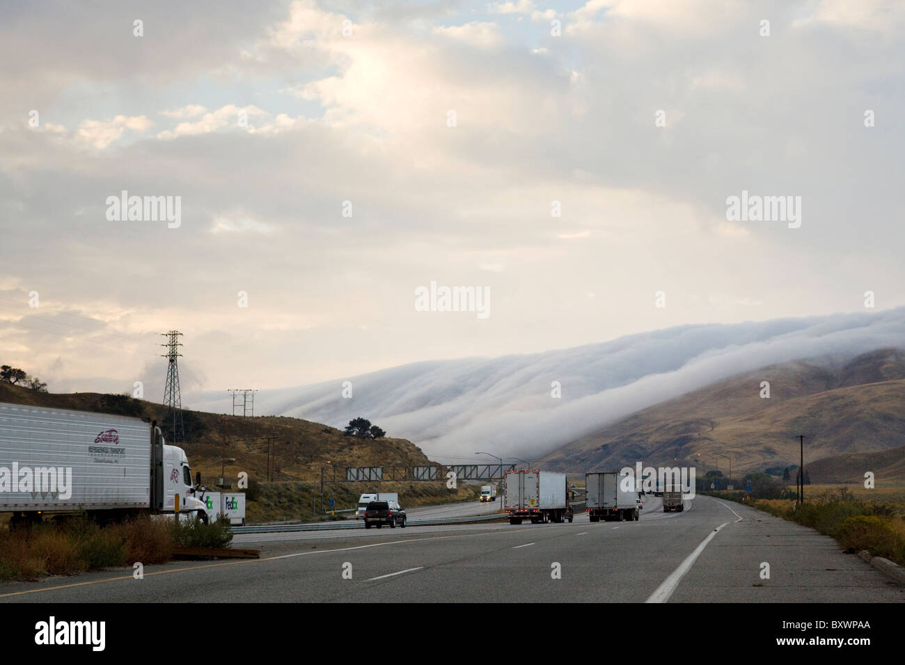 Nebbia rotolamento sulla collina lungo la trafficata autostrada - Pass Tejon, California USA Foto Stock