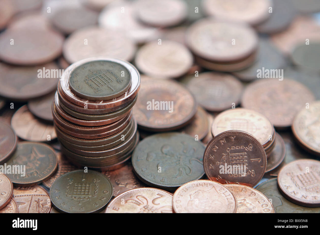 Una sterlina 1p moneta su una pila di 2p delle monete in euro - tutti in piedi su una ridda di 2p e 1p delle monete in euro Foto Stock