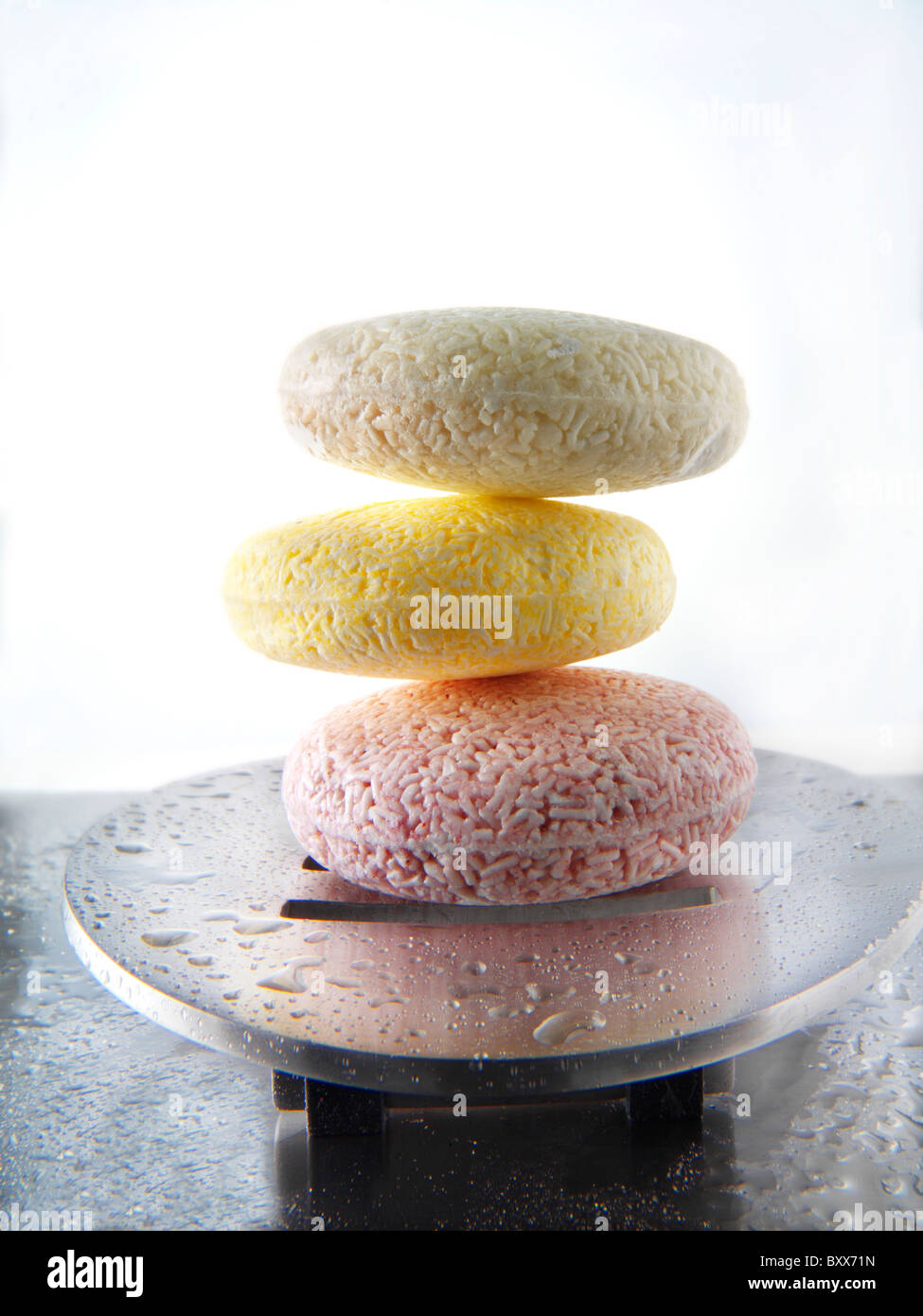 Le barre colorate di fatto a mano Saponi profumati impilati in un moderno sapone metallico piatto. Foto Stock