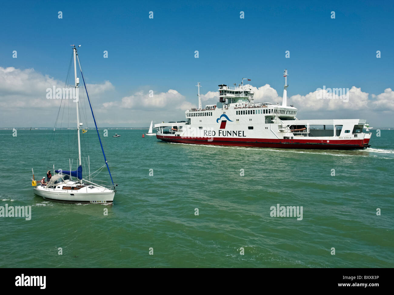Una barca a vela passa Red Funnel Aquila Rossa nel Solent off Cowes nell'Isola di Wight in Inghilterra Foto Stock