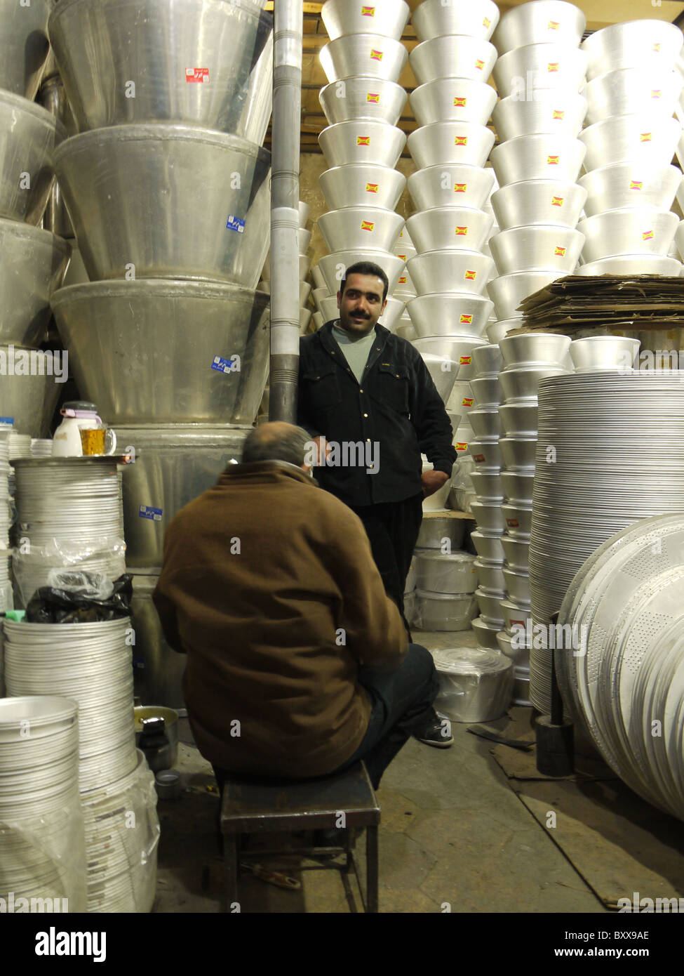 Gli uomini la vendita di pentole e padelle nel bazaar Shiraz Iran Foto Stock