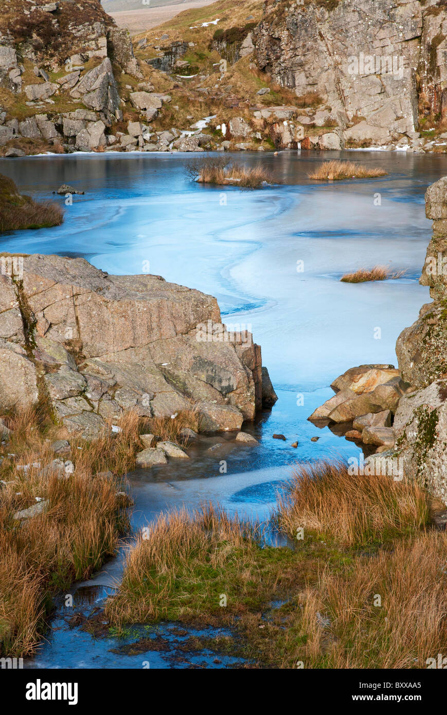 Iced su acqua in Foggin Tor cava durante il freddo inverno magia, Dartmoor Devon UK Foto Stock