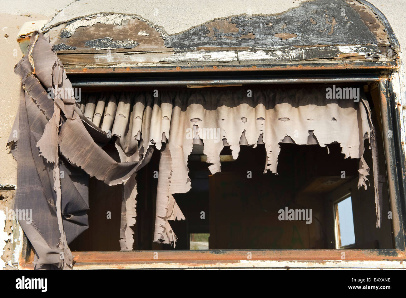 Le tende nella finestra di abbandono di rimorchio o caravan, Salton Sea Beach, nel sud della California, Stati Uniti d'America. Foto Stock