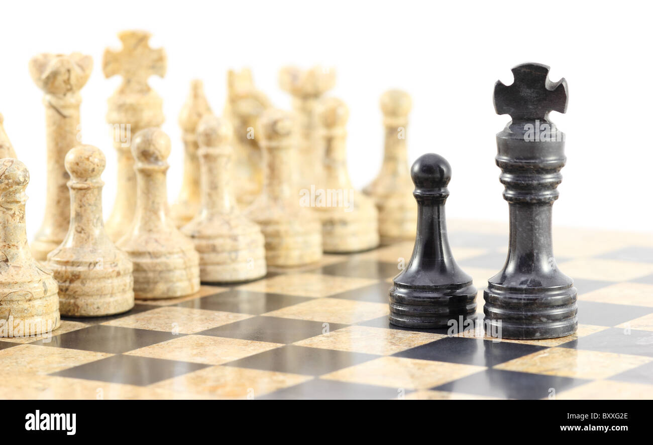 La fedeltà al Re - una pedina e il suo re face off contro l'intero esercito di opposti pezzi di scacchi. Foto Stock