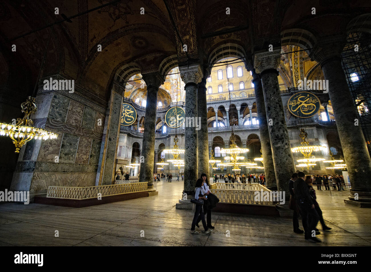 Hagia Sophia Interior Istanbul Turchia // ISTANBUL, Turchia - la vasta sala principale di Hagia Sophia mostra il suo notevole design architettonico bizantino, con la sua imponente cupola centrale supportata da pendenti e semi-cupole. L'interno presenta elementi cristiani e islamici, tra cui mosaici bizantini, calligrafia ottomana e grandi avize ottomane (lampadari). Enormi colonne e pannelli in marmo rivestono lo spazio, dimostrando la grandezza dell'ingegneria architettonica del vi secolo. Foto Stock