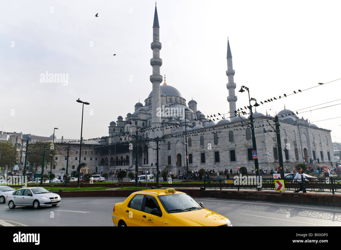 Nuova Moschea Yeni Camii Istanbul Turchia // ISTANBUL, Turchia — Yeni Camii (nota anche come nuova Moschea o Yeni valide Sultan Camii) domina il paesaggio urbano nel quartiere di Eminönü vicino al lungomare del Corno d'Oro. La moschea imperiale ottomana, costruita tra il 1597 e il 1665 sotto il patrocinio di due potenti valide Sultani, rappresenta l'ultimo esempio di architettura classica della moschea ottomana. La caratteristica cupola centrale della moschea e la disposizione piramidale di 66 cupole e semi-cupole creano una presenza monumentale sopra il tessuto urbano circostante. Situato accanto allo storico Spice Bazaar, Th Foto Stock
