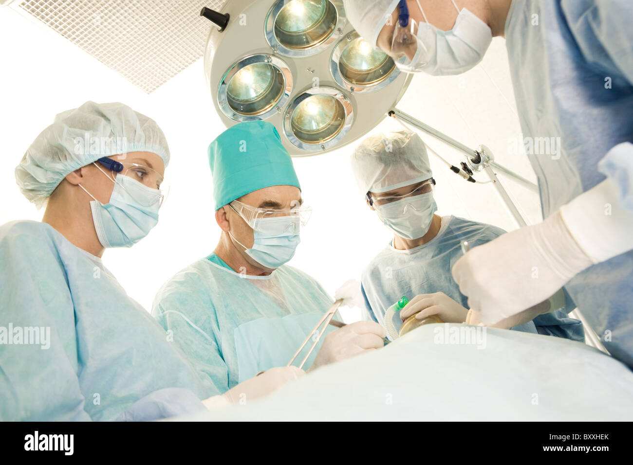 Immagine di chirurghi e infermieri in prossimità del paziente disteso sul tavolo operatorio Foto Stock