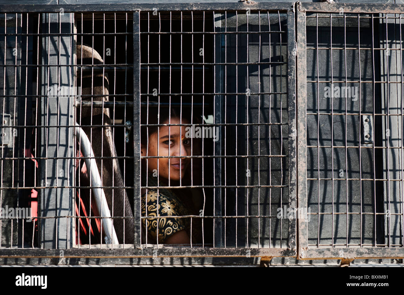 Indian ragazza adolescente in una scuola bus dietro una finestra a maglie di filo. Andhra Pradesh, India Foto Stock