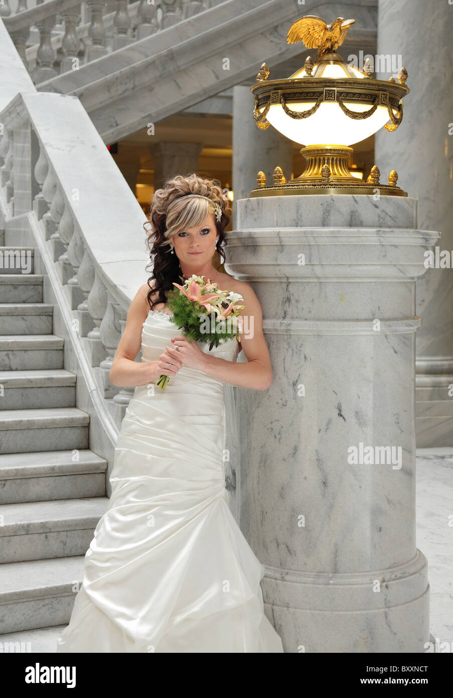 Bella sposa moderna in piedi vicino a scalinata di marmo Foto Stock