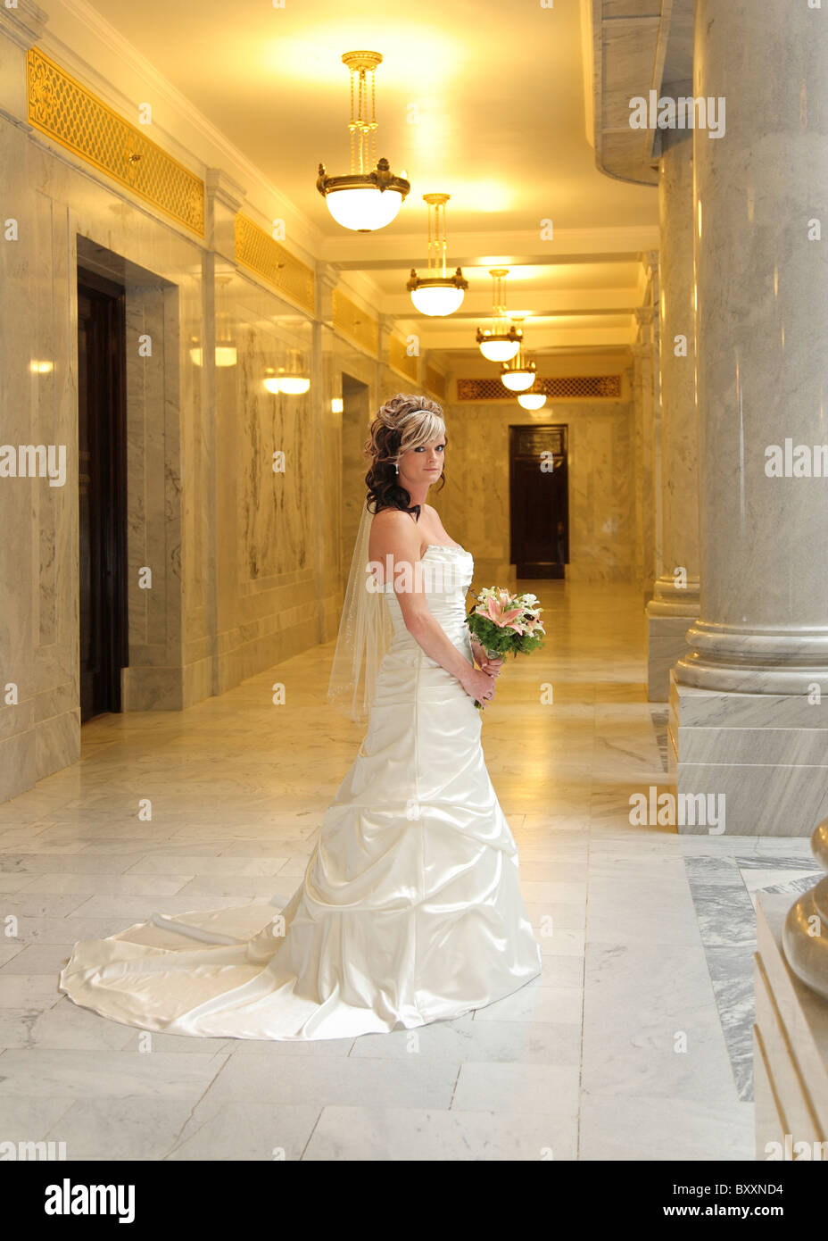 Bella Sposa contemporanea in piedi con bouquet Foto Stock