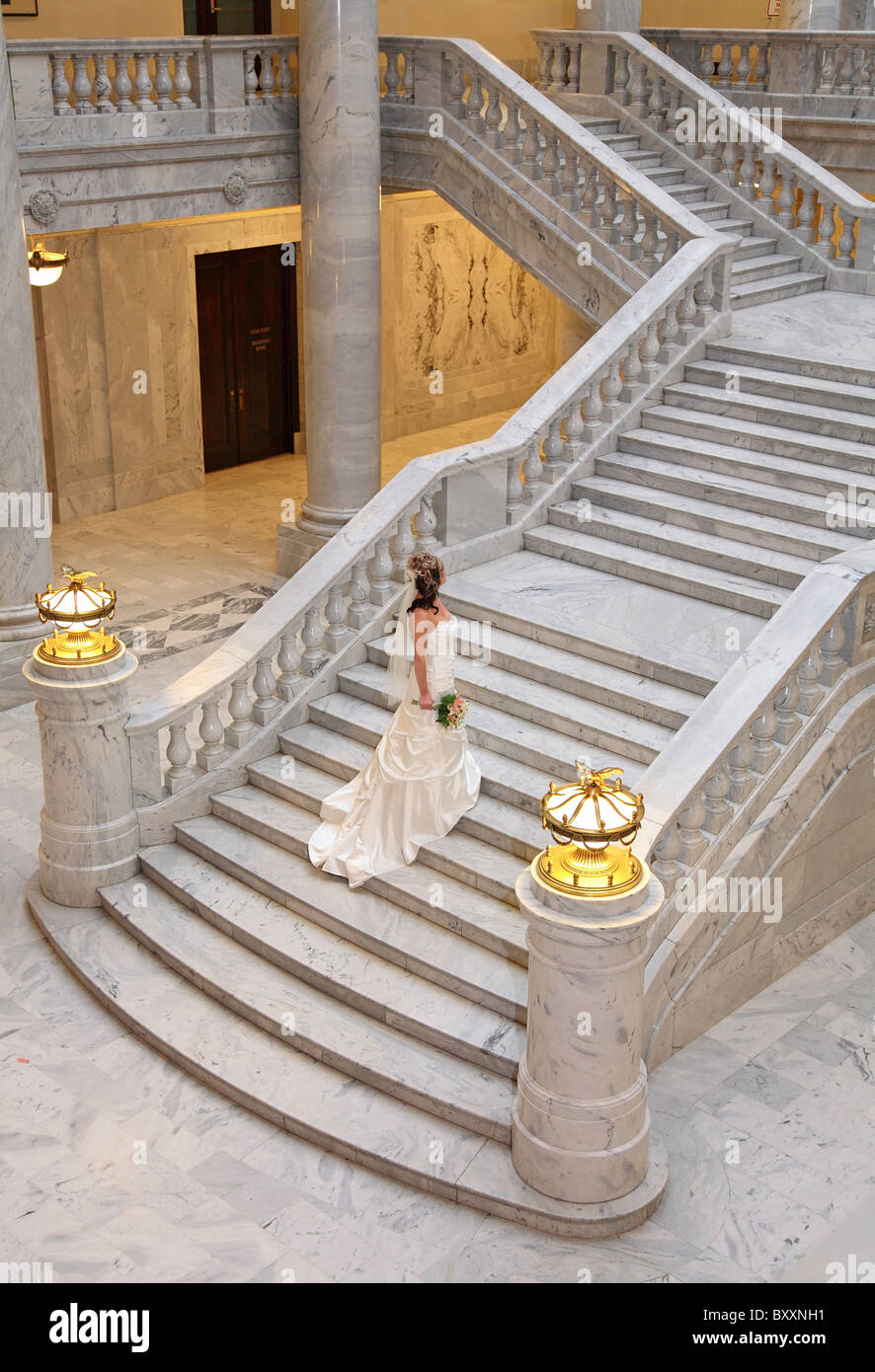 Montare Caucasian sposa a camminare su grande scala di marmo Foto Stock
