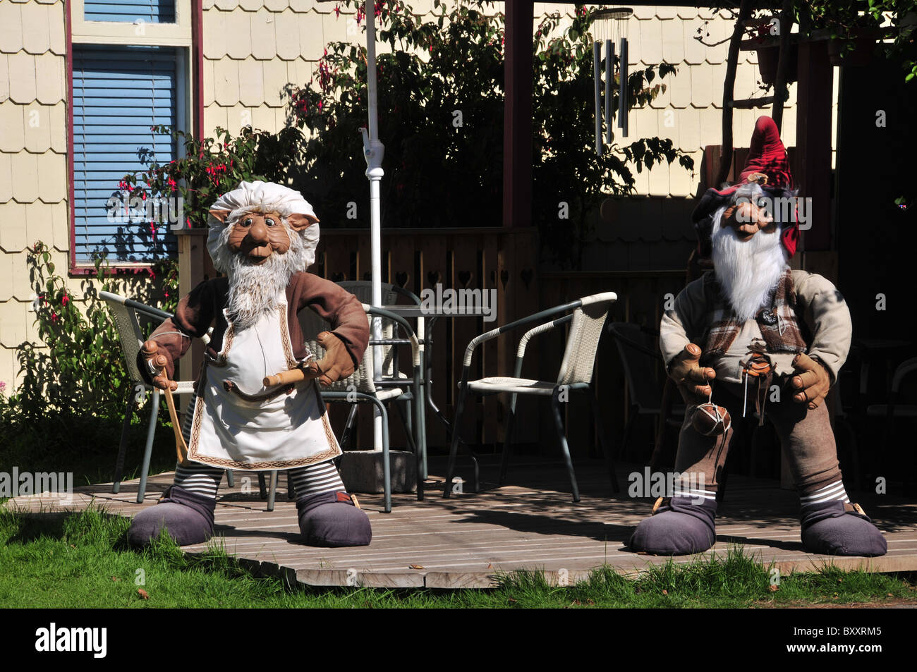 Due grandi Chilean-German gnome effigi, uno con il mattarello e panettiere hat, in piedi al di fuori di un ristorante, Frutillar, Cile Foto Stock