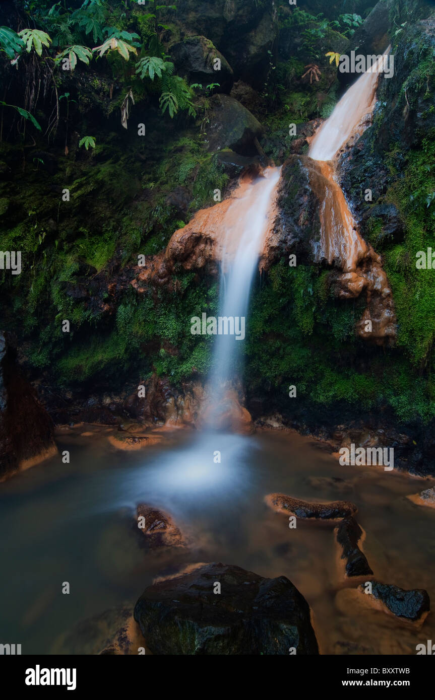 Cascata e streaming da isole Azzorre. Si tratta di calda acqua vulcanica con una elevata concentrazione di ferro quindi il colore arancione. Foto Stock
