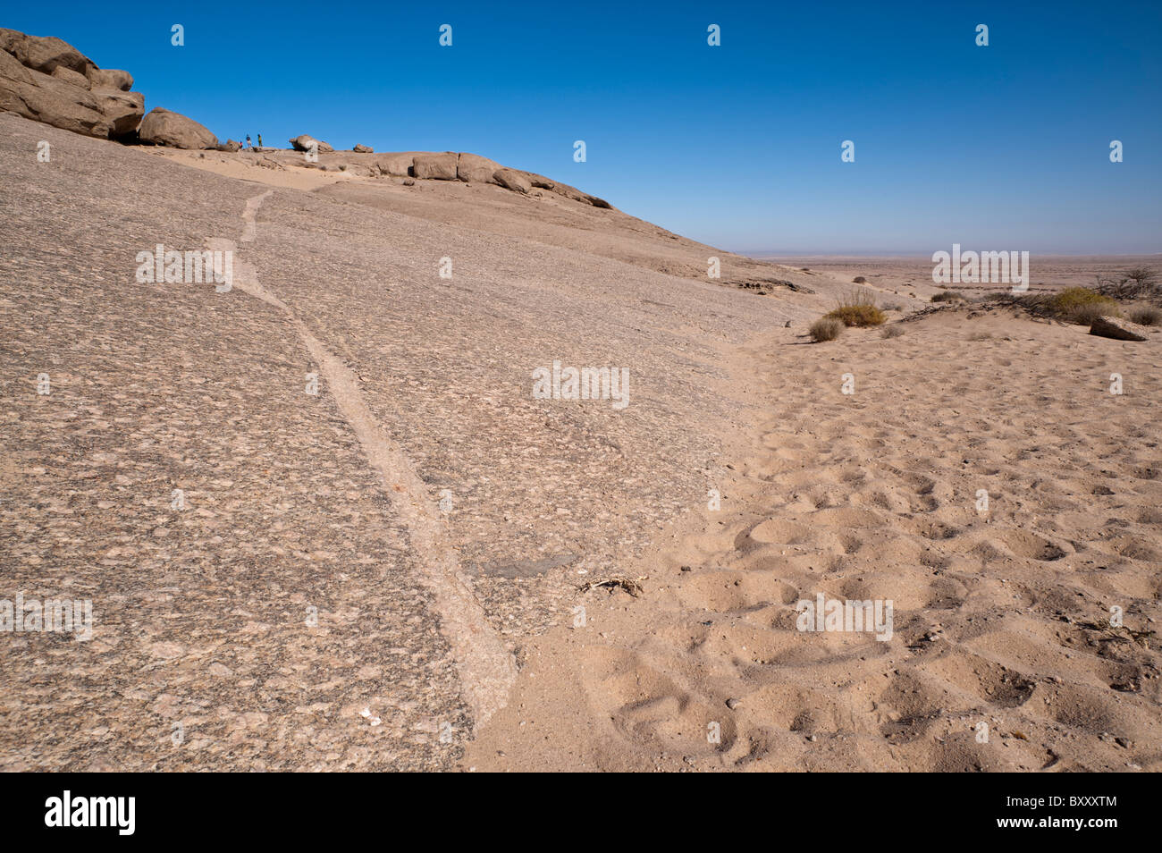 Un magma intrusivo diga può essere visto in esecuzione attraverso il monolito di granito di Vogelfederberg, inselberg isolata nel deserto del Namib vicino a Walvis Bay Foto Stock