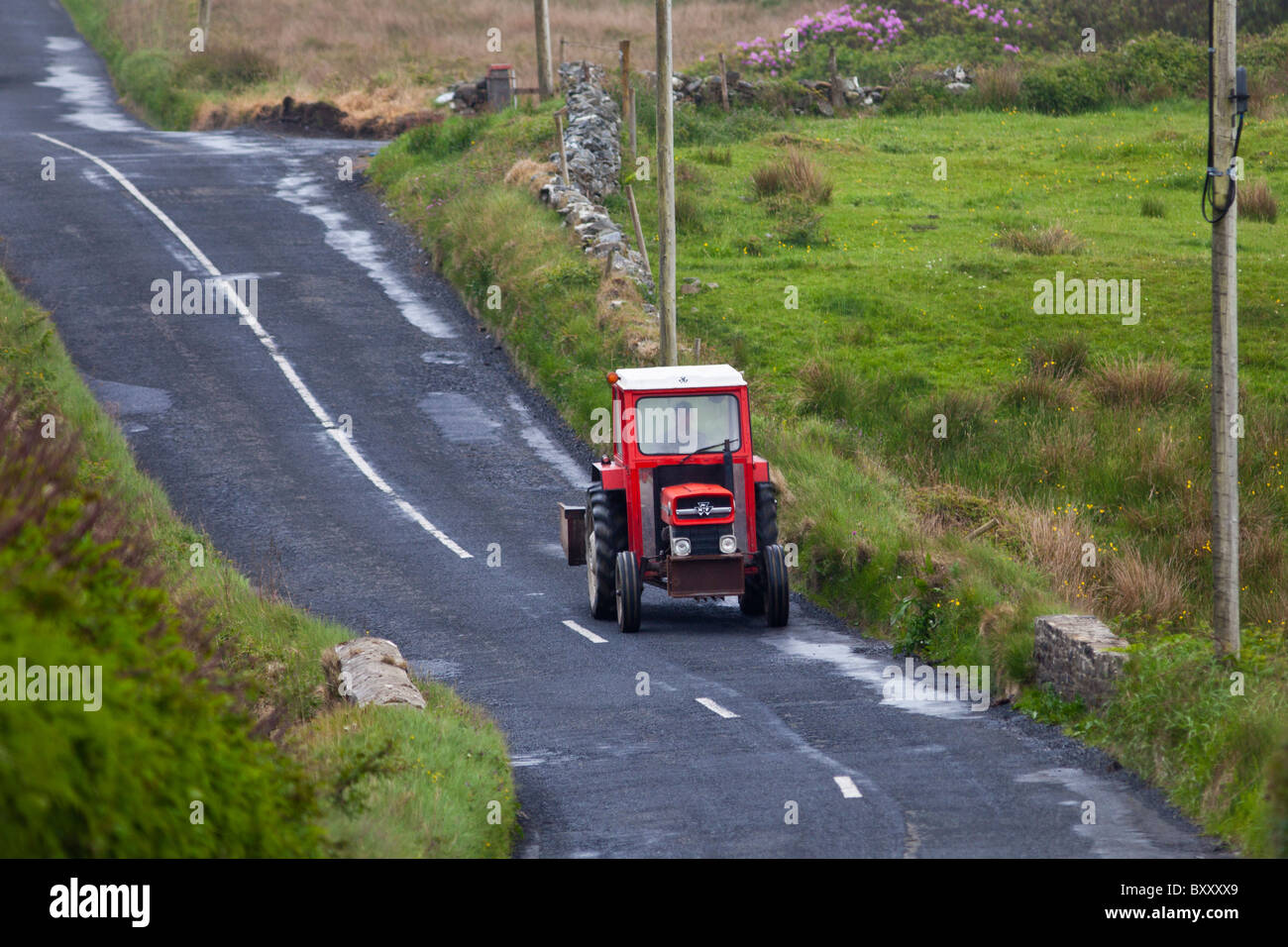 Piccola fattoria il trattore nelle corsie nella contea di Clare, Irlanda occidentale Foto Stock