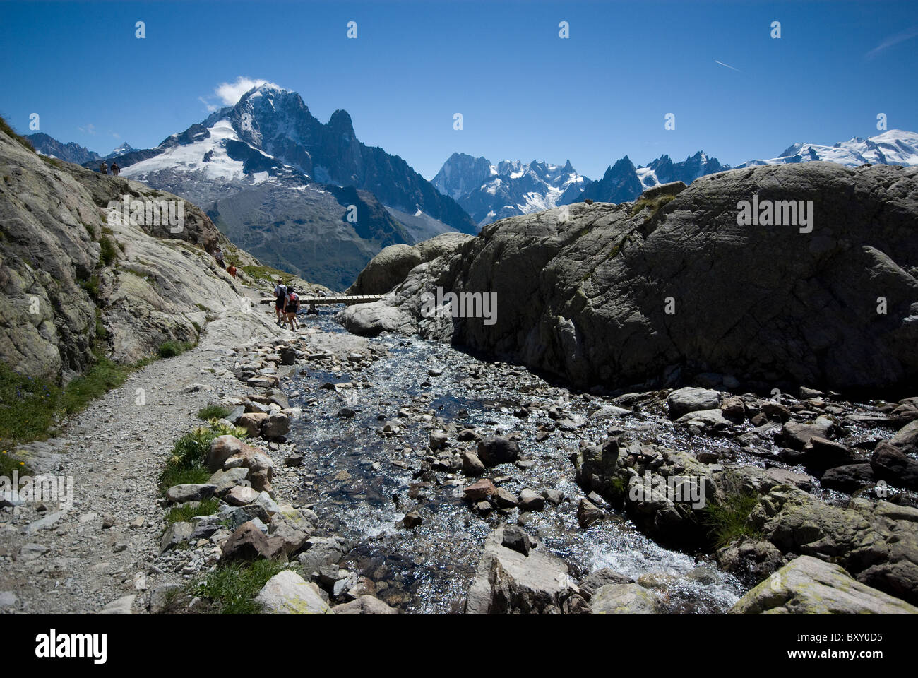 Un fiume conduce dal Lac Blanc, di fronte a picchi di Aiguille Verte e Mont Blanc, sulle alpi francesi. Foto Stock