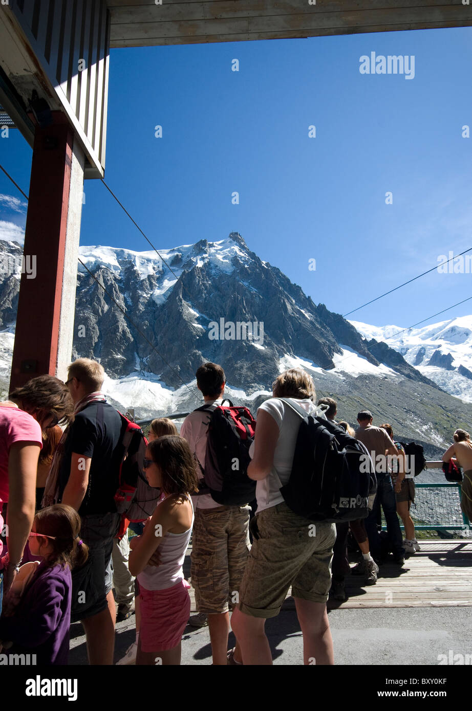 I turisti in coda per la funivia per Auguille du Midi - il picco nella distanza, Haute Savoie, alpi, Francia Foto Stock