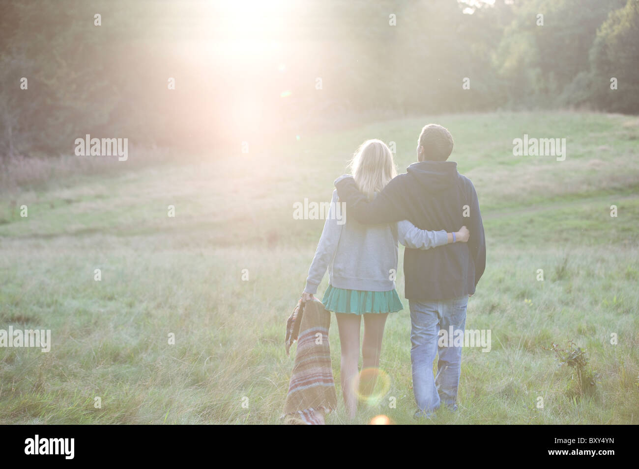 Vista posteriore di una coppia giovane passeggiate in campagna Foto Stock