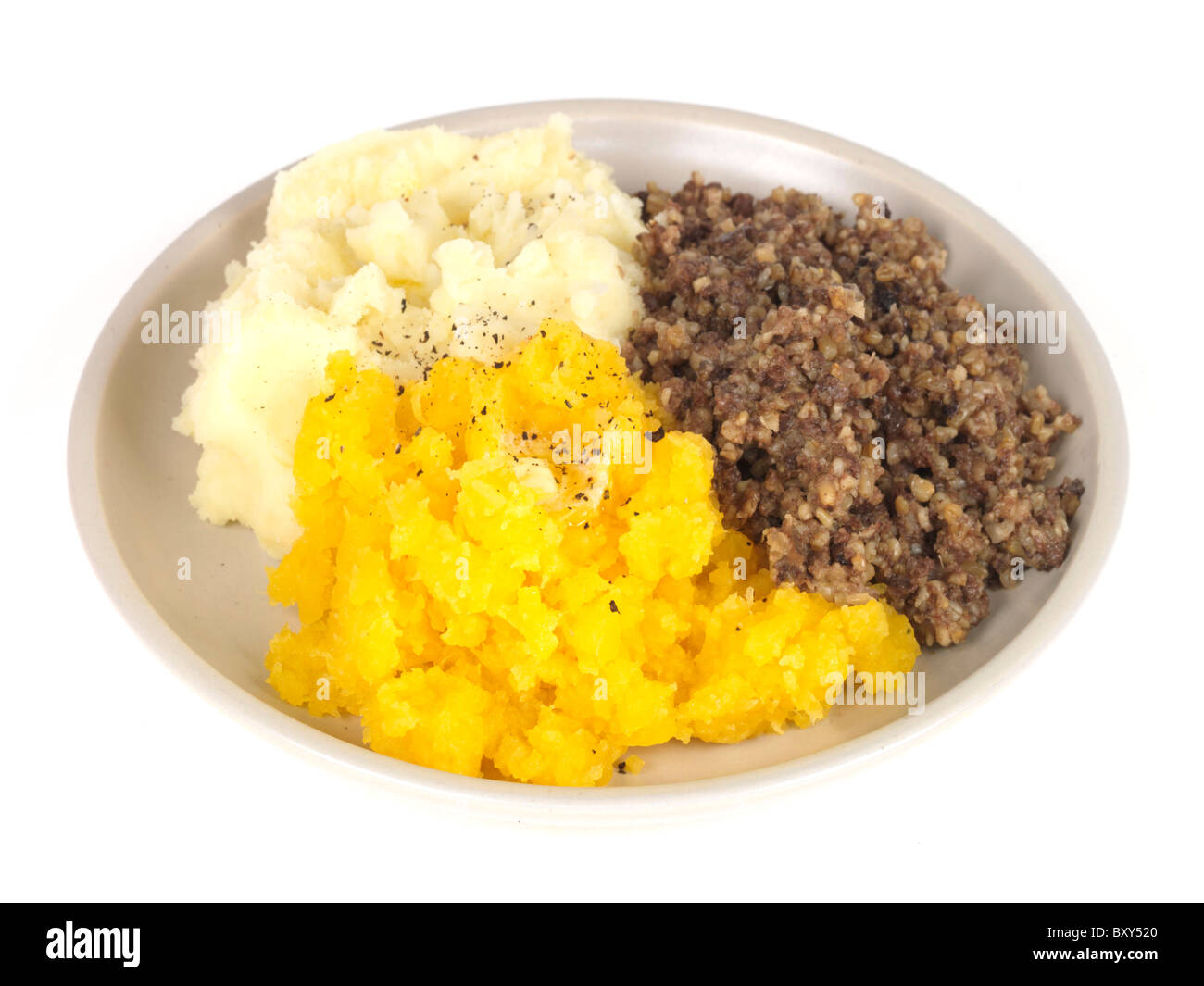 Autentico stile Scottish brucia notte Haggis con svedese e purè di patate contro uno sfondo bianco con nessun popolo e un tracciato di ritaglio Foto Stock