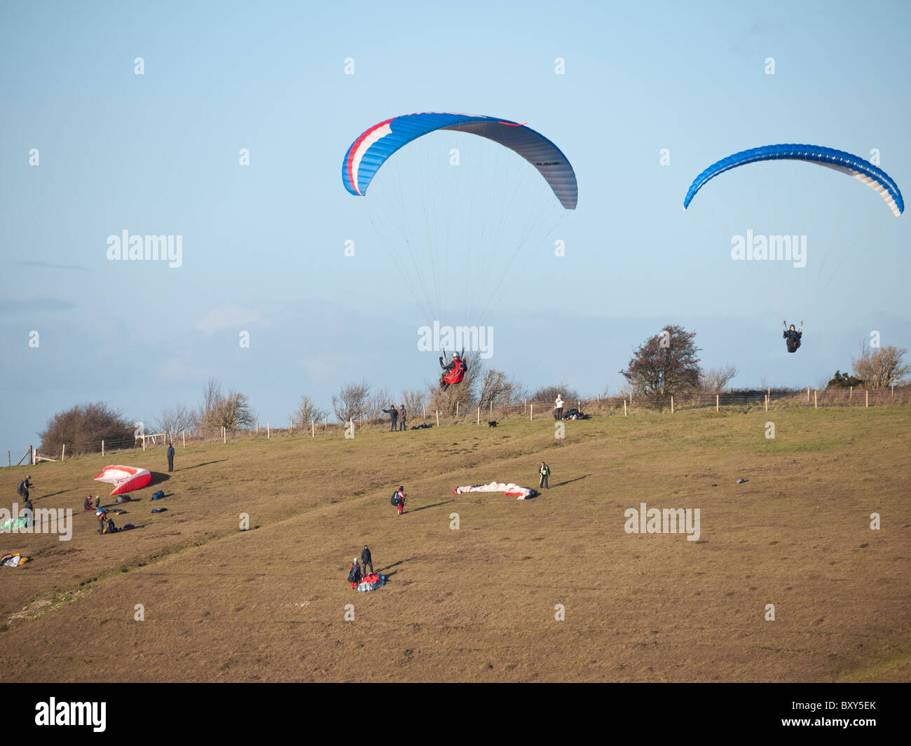 I piloti battenti parapendii al latte collina a nord di Alton Barnes, vicino a Marlborough nel Wiltshire, Inghilterra. Foto Stock